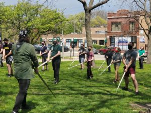 Picture of longsword students learning a low guard outside in the park 