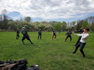 Students practicing their lunge outside in a park